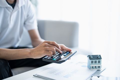 Mann tippt auf Taschenrechner