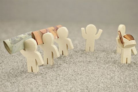 Kleine Figuren mit Geldscheinen und Münzen