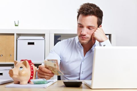 Mann mit Taschenrechner und Bargeld