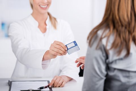 Patientin und Arzthelferin mit Versicherungskarte 